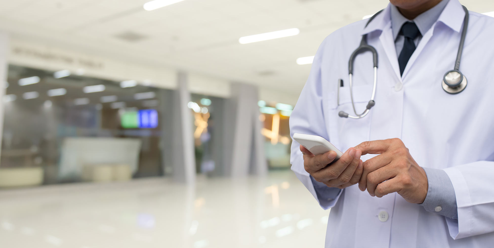 A doctor uses SMS services for healthcare in a hospital setting.